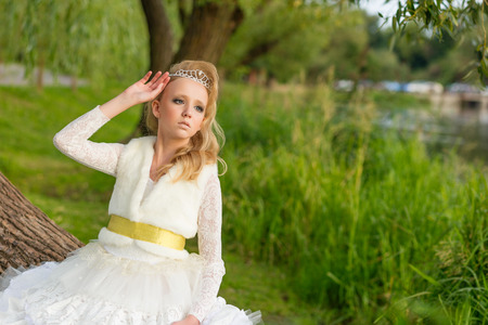 Fashion photo of a young girl in a beautiful white dress. Blonde girl in the image of the doll. Bride.の写真素材