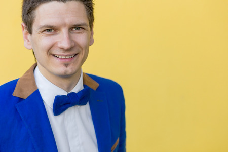 Portrait of a man in a blue jacket on a yellow background