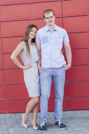 Portrait of happy guy and girl on red backgroundの写真素材