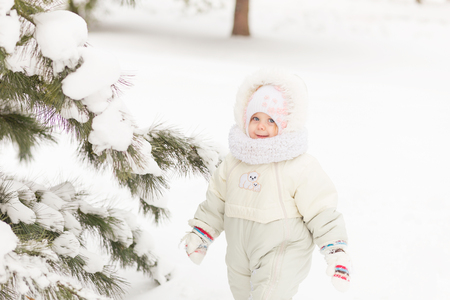 Portrait of a Girl in the winter forest. A child playing in the snowの写真素材