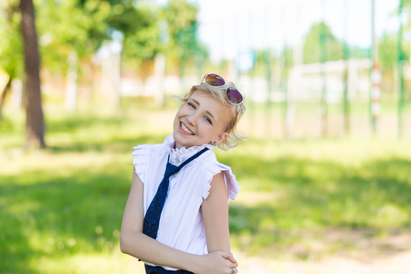 The girl is resting in the schoolyard. Schoolgirls in vintage school uniform.の写真素材
