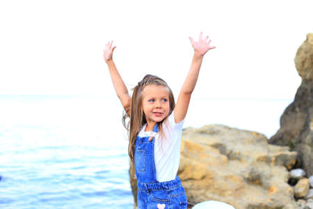 A child on the stones near the sea in summerの写真素材