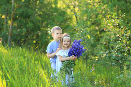Little boy hugs a girl on the nature in summerの写真素材