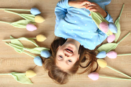 Beautiful girl lies on the floor among handmade flowersの写真素材