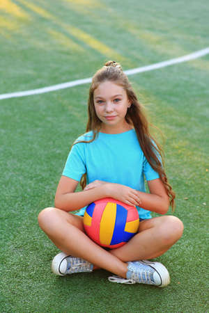 Girl with a ball in his hands on the football field.の写真素材