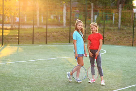 Two girls with badminton rackets on the football field.の写真素材