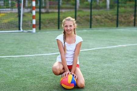 Girl with a ball in her hands on the playgroundの写真素材