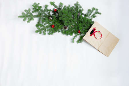 Spruce branches with New Years toys and a gift bag lie on a white background.の写真素材