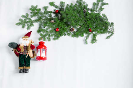 Green tree decorated with Christmas balls and a red lamp and Santa.