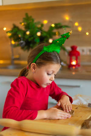 Happy little girl prepares cookies on the eve of christmas.
