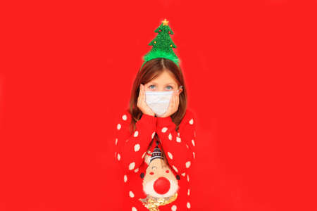 Girl in a red Christmas sweater during the quarantine periodの写真素材