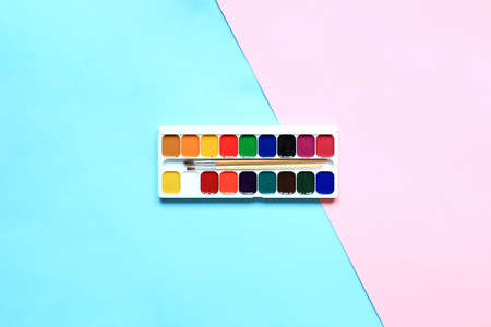A set of paints and pencils for drawing on a pink background. Stationery for school. Layout of goods for the artist. View from above.の写真素材