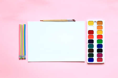 A set of paints and pencils for drawing on a pink background. Stationery for school. Layout of goods for the artist. View from above.の写真素材