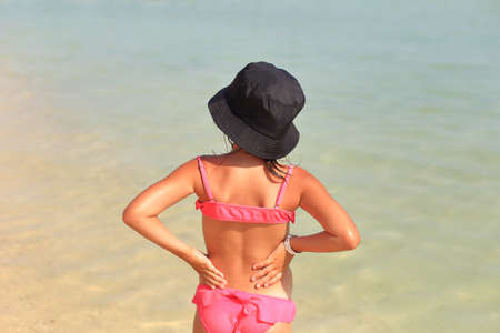 The child is resting in the summer on the sea. A tanned girl goes to the sea. Summer holiday with a child on the seaの写真素材