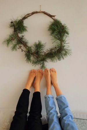 two pairs of unpolished feet playfully raised against a backdrop of delightful Christmas...