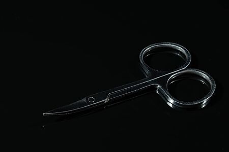 steel scissors for manicure on a black mirror surfaceの写真素材