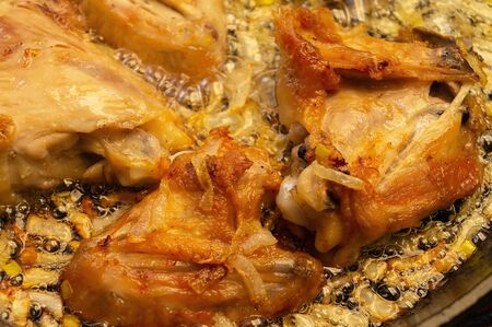 Golden pieces of chicken during frying in a pan. Golden pieces of fried chicken cooking process