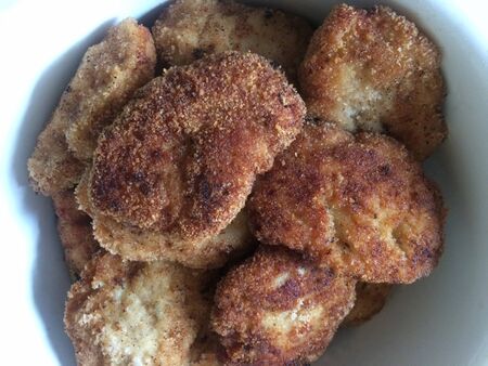 Fried cutlets in breadcrumbs lie in a white plate top view