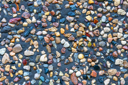 small multi-colored stones pressed into the gray ground. background from small bright multi-colored lumps of different rocks. fine crushed stone texture with uniform cleaning top viewの写真素材