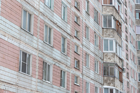 The facade of a multi-storey residential building requires repair. Not pretty building facades awaiting renovationの写真素材