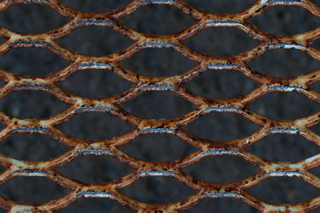 metal rusty grill on defocused gray background. background old grill with rust