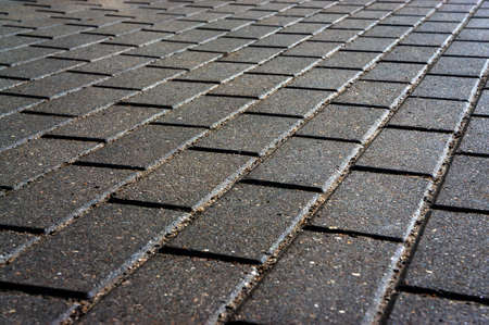 abstract background wet after the rain paving slabs illuminated by the warm light of the setting sun