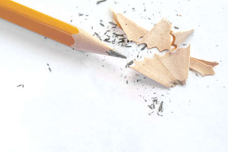 the pencil after sharpening lies on a white background next to the scalesの写真素材