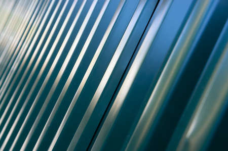 blue geometric abstraction diagonal lines of a metal fence from a metal profile in a defocused perspectiveの写真素材