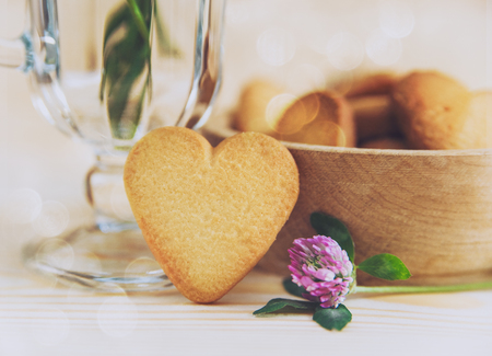 Heart shaped cookie on wooden table backgroundの写真素材