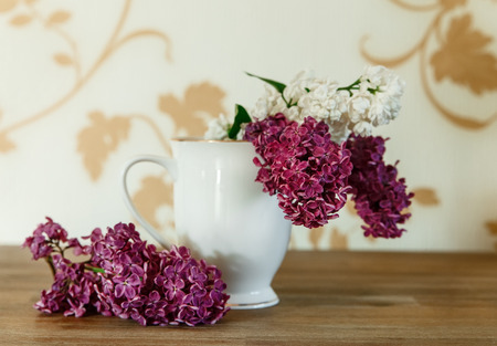 Two Branch of White and Purple Lilac in the Ceramic Cup.Wooden Background,Selective Focusの写真素材