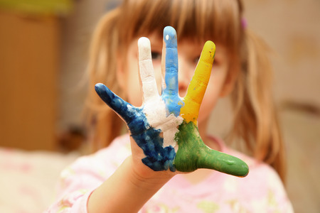 little girl with hands in paintの写真素材