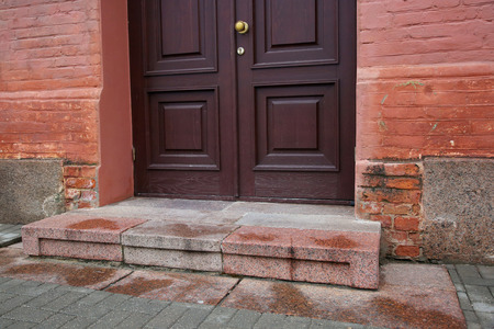Porch with dark door of red bricked buildingの写真素材