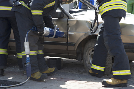 firefighters with the pneumatic shears open the car doors after a car accident