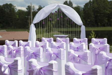 wedding decorations: chairs with bows and archの写真素材