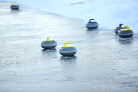 granite stones for curling on ice of frozen lakeの写真素材