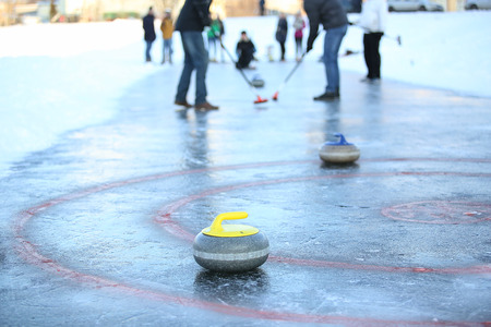People playing in curling on the surface of frozen lakeの写真素材