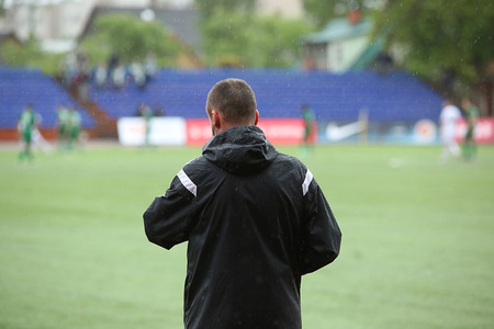 Footbal coach watching the match at rainy timeの写真素材