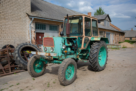 Old tractor at the village in sunny day