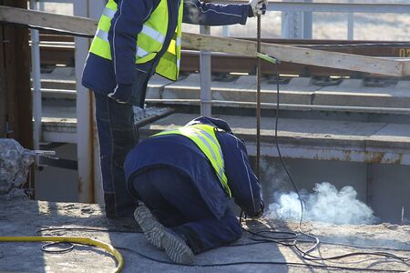 Industrial construction worker using a professional angle grinder for cutting asphalt