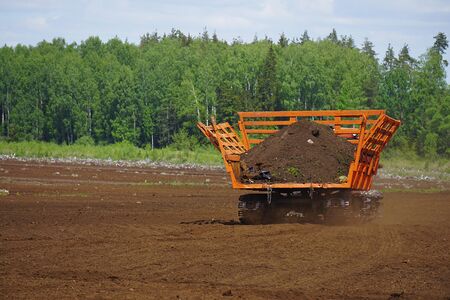 Orange peat truck in the tuef fieldの写真素材