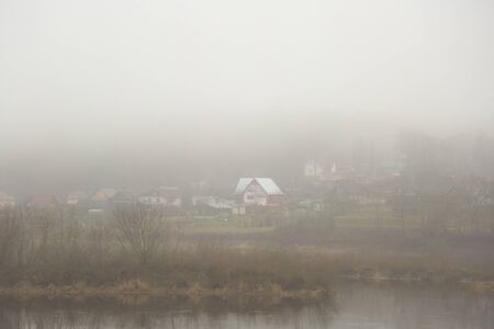 View on the coast of river with frog and little housesの写真素材