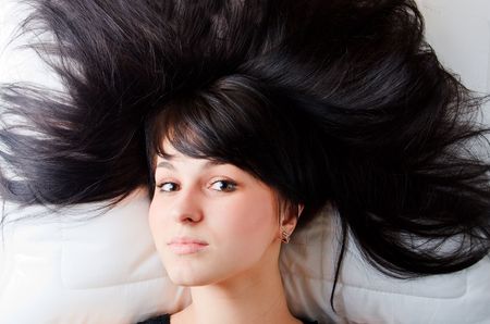 Beautiful young girl lying on the bedの写真素材