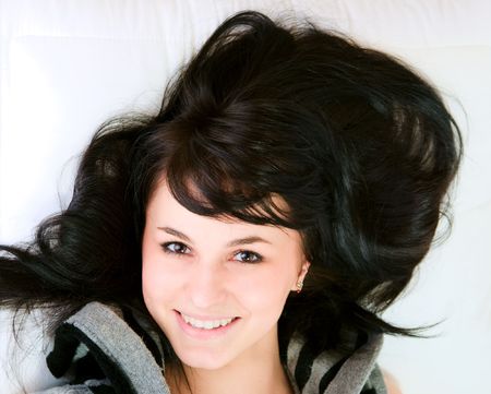 Beautiful young girl lying on the bedの写真素材