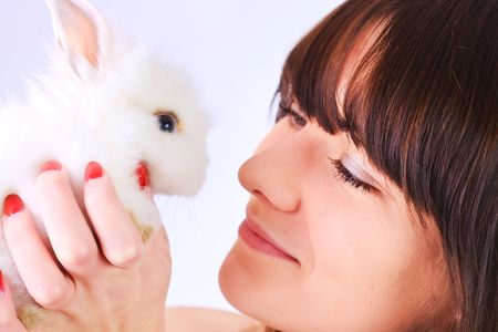 Young girl holding a white little rabbitの写真素材