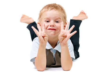 Young boy lying on stomach in studioの写真素材