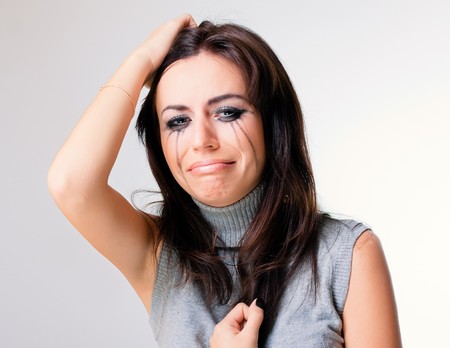 Crying woman towards grey backgroundの写真素材