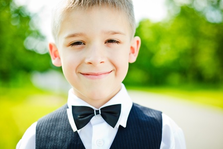 Little boy in a shirt and vest in parkの写真素材