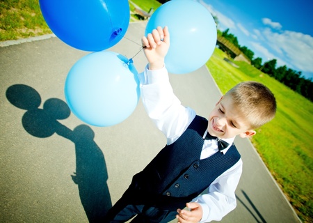 Young boy moving with balloonsの写真素材