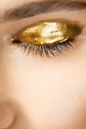 Beautiful female eye with golden make-upの写真素材