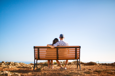Romantic couple on bench on the edge of earthの写真素材